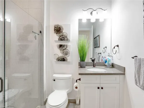 a bathroom with a granite countertop sink toilet and shower