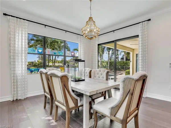 a dining room with furniture a chandelier and wooden floor