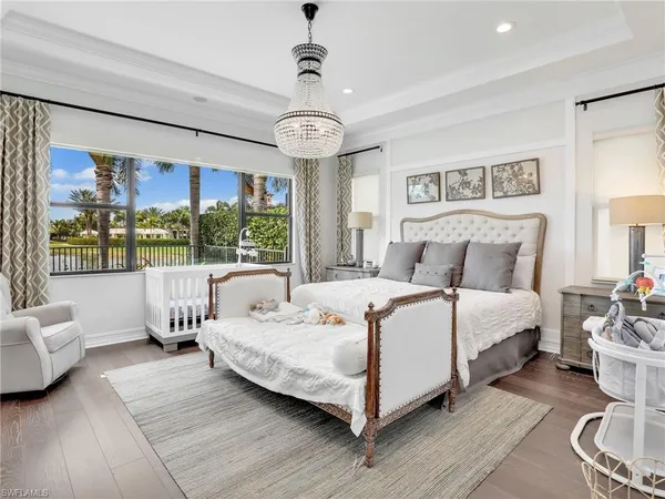 a bedroom with a large bed and a chandelier