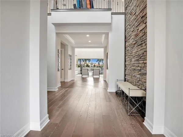 a hallway with wooden floor chandelier