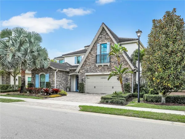a front view of a house with a garden and plants