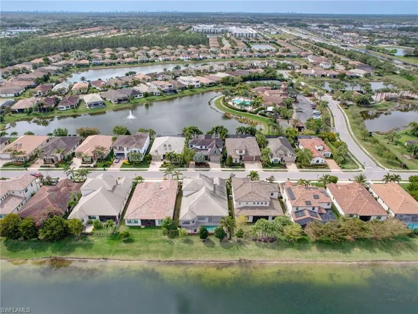 an aerial view of residential houses with outdoor space and lake view