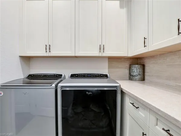 a kitchen with granite countertop white cabinets and a stove top oven