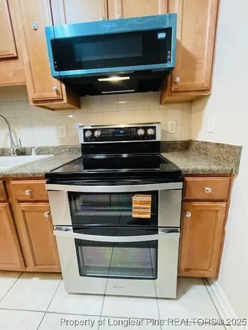 a stove top oven sitting inside of a kitchen