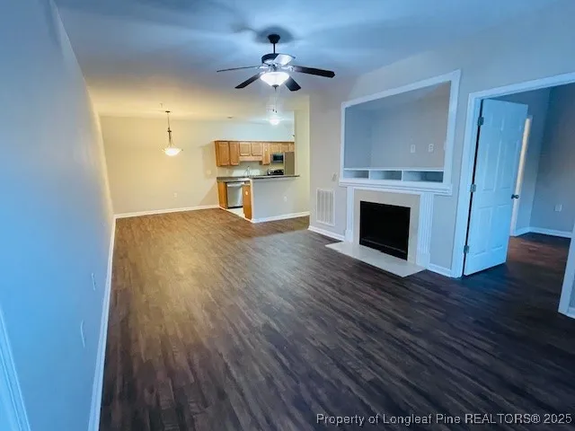 a view of an empty room with a fireplace and a window