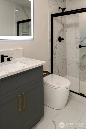 a bathroom with a granite countertop sink a toilet and shower