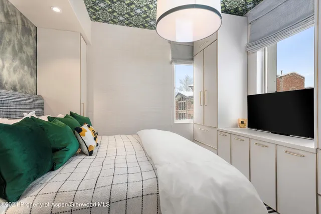 a bedroom with a bed and a flat screen tv