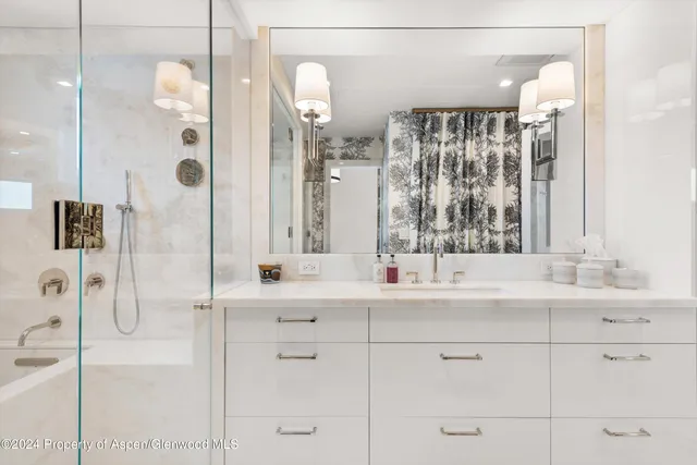 a bathroom with a double vanity sink mirror and shower