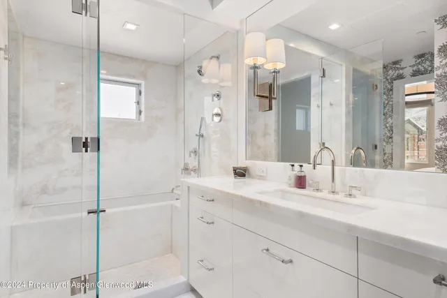 a bathroom with a double vanity sink mirror and shower