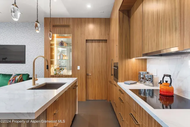 a kitchen with stainless steel appliances granite countertop a sink and a refrigerator