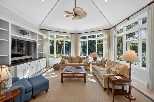 a living room with furniture and floor to ceiling windows