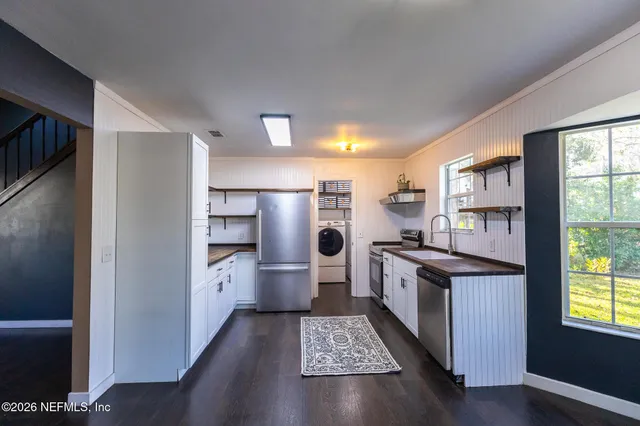 a kitchen with stainless steel appliances granite countertop a refrigerator a stove and a sink