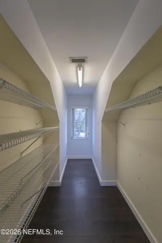 a view of a livingroom with a chandelier fan and wooden floor