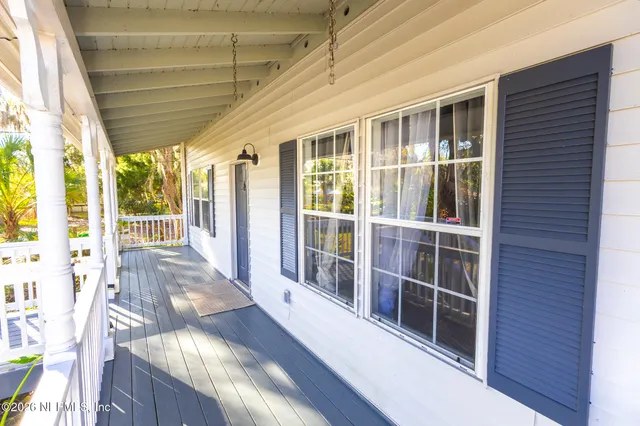 a front view of a house with a yard and large trees