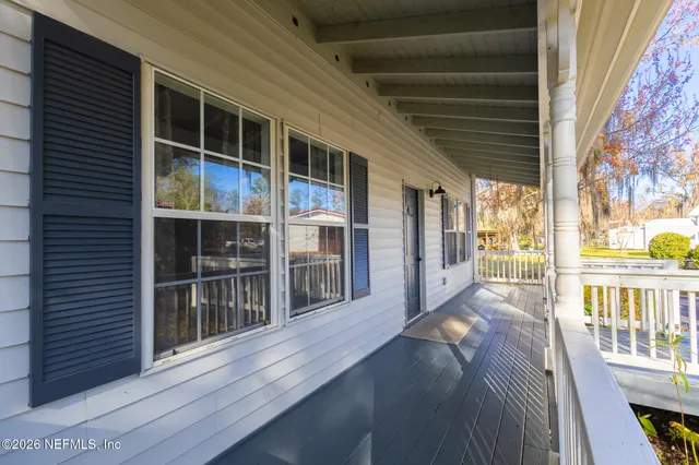 a backyard of a house with wooden fence and a large tree