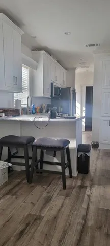 a kitchen with a table chairs sink and cabinets