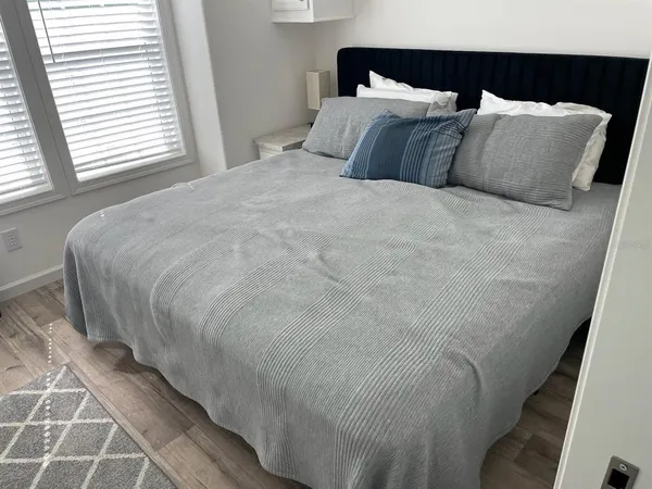 a large bed sitting in a bedroom next to a window