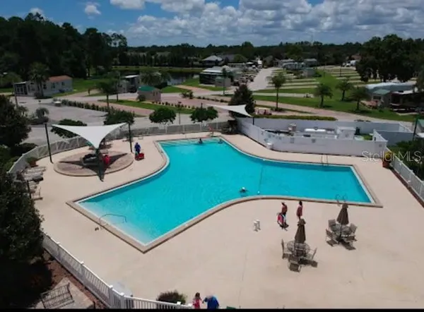 an aerial view of a swimming pool and lounge chairs