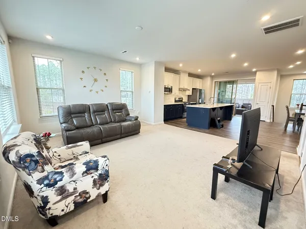 a living room with furniture and a dining table with kitchen view