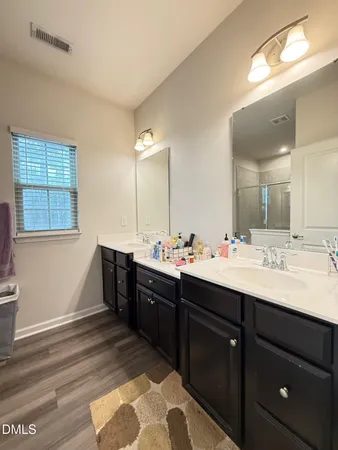 a bathroom with a double vanity sink and a mirror