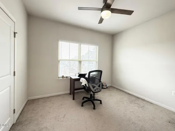 a view of a workspace with furniture and a window