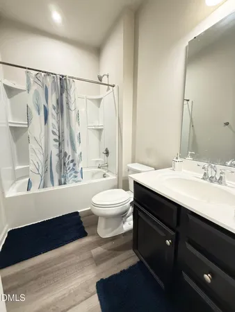 a bathroom with a sink a toilet a mirror and shower