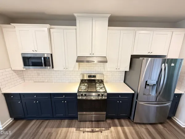 a view of a kitchen with a sink cabinet and a refrigerator