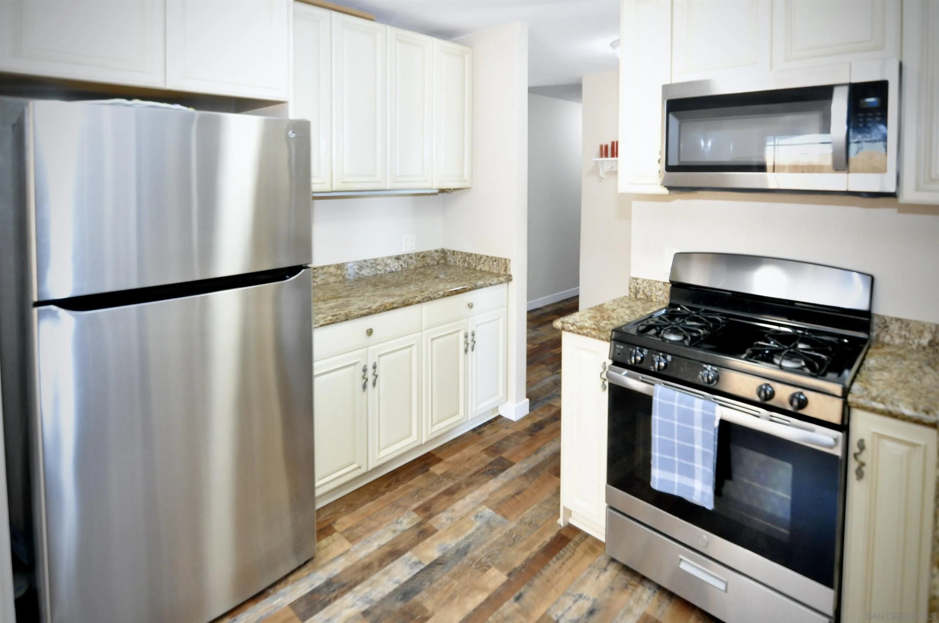 14333 Lolin Lane Poway, CA 92064 - Photo 32 of 41 a kitchen with granite countertop a refrigerator stove and microwave
