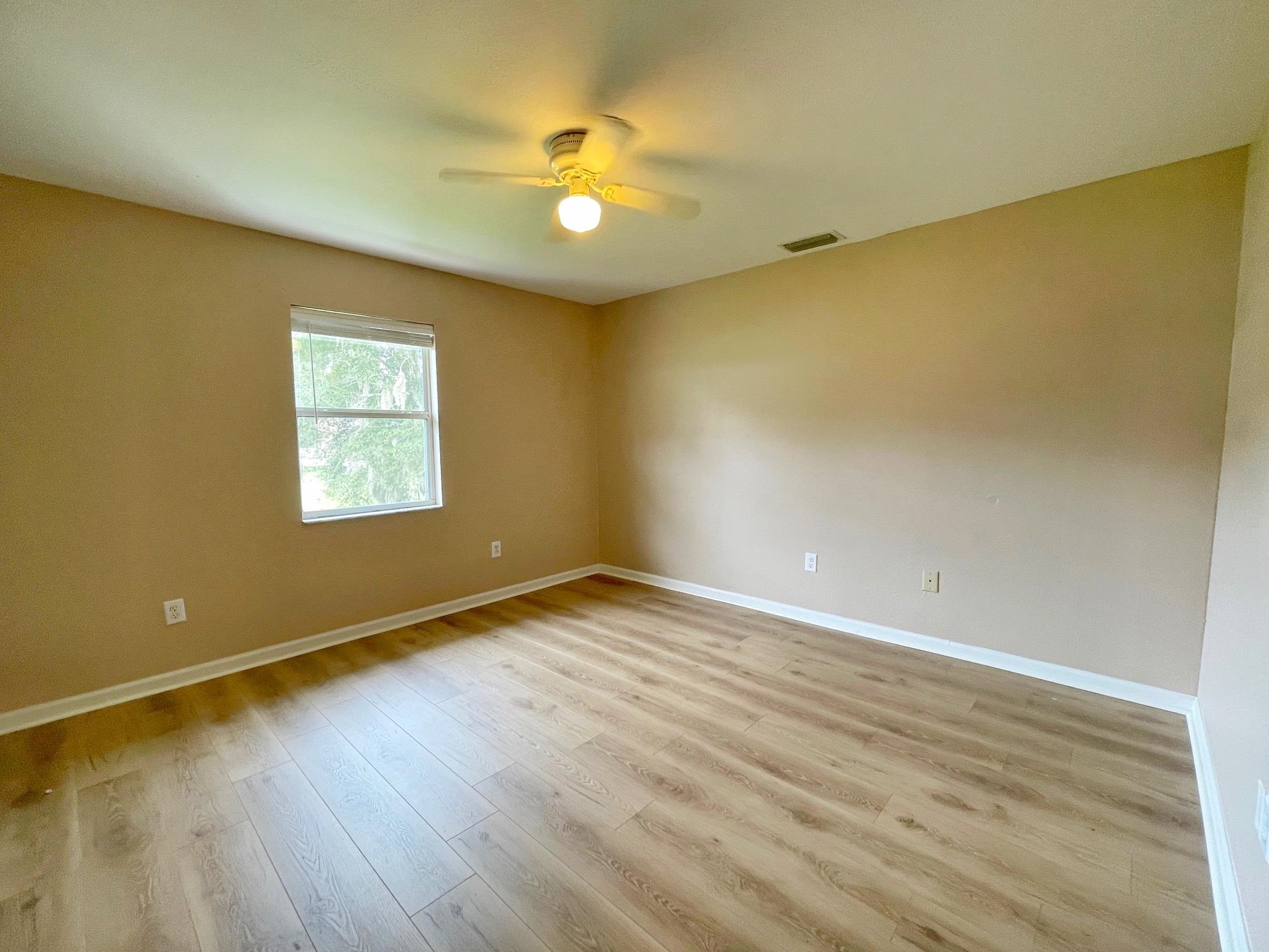 4420 Carter Road, Unit 35 St. Augustine, FL 32086 - Photo 10 of 20 a view of an empty room with wooden floor and a window