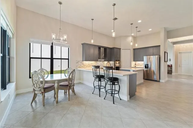 a kitchen with stainless steel appliances kitchen island granite top and refrigerator