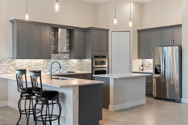a kitchen with stainless steel appliances granite countertop a refrigerator and a stove top oven