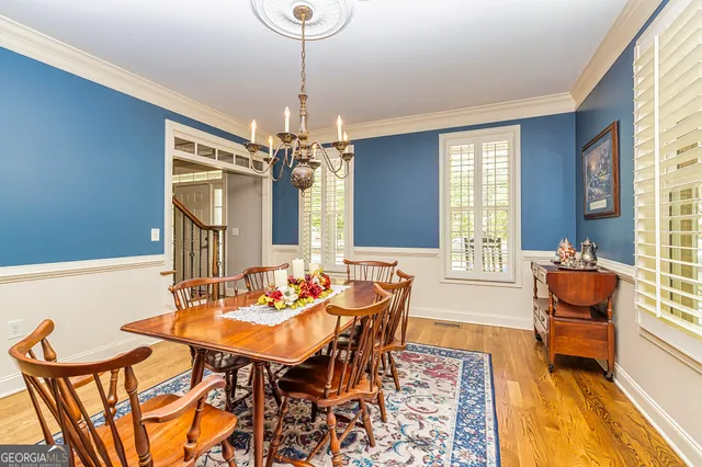a kitchen with stainless steel appliances kitchen island granite countertop a table chairs and a refrigerator
