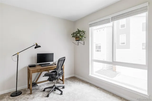 a view of a workspace with furniture and a window