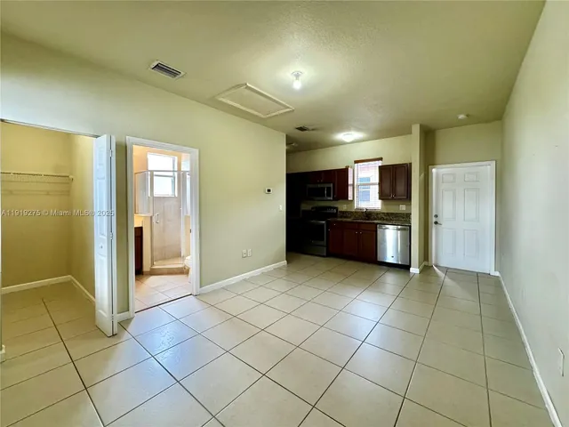 a view of a kitchen with refrigerator and more cabinets