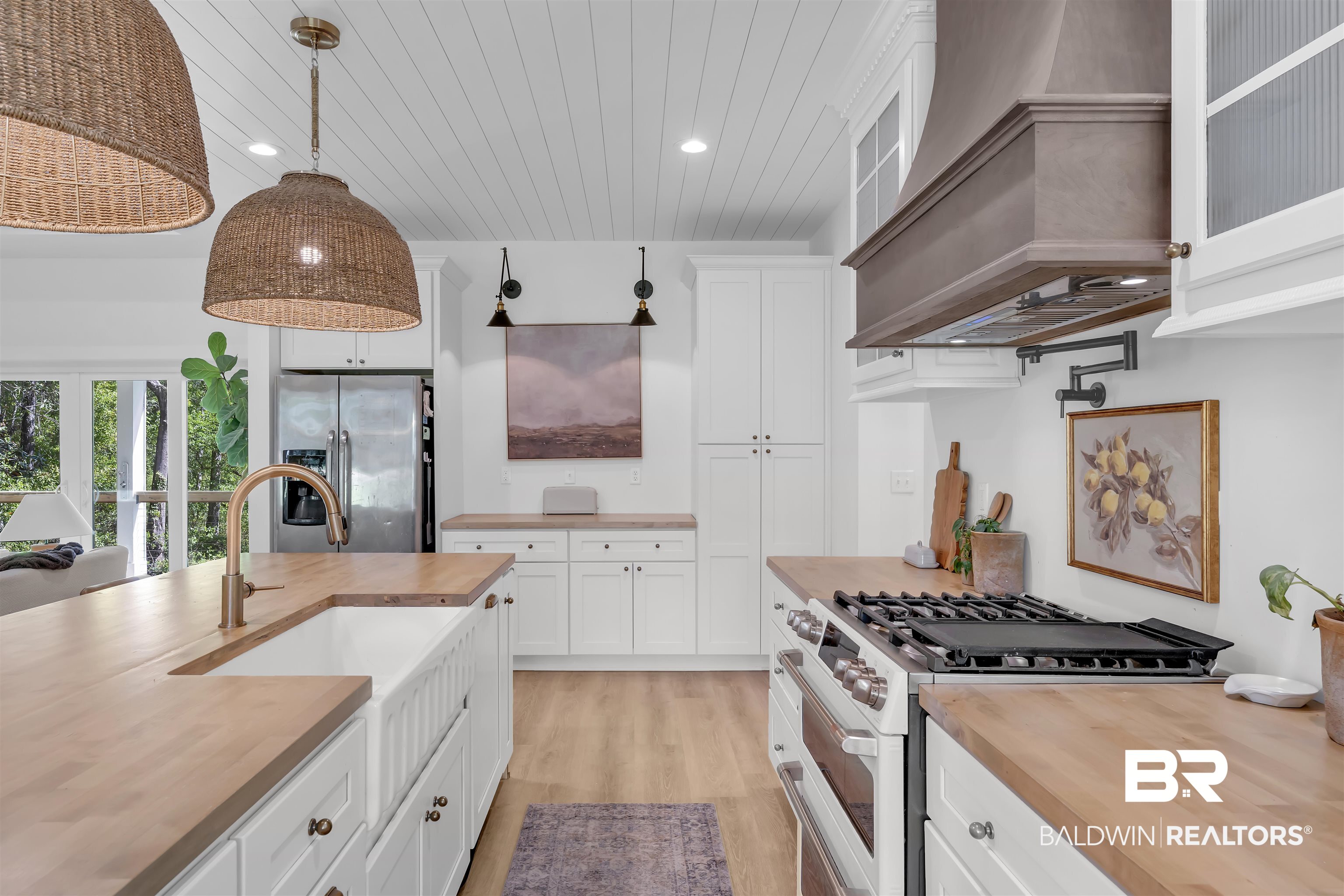 19058 James Road Gulf Shores, AL 36542 - Photo 13 of 49 Kitchen with butcher block countertops, white gas range oven, white cabinets, decorative light fixtures, and wood ceiling