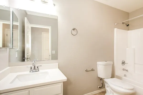 a bathroom with a sink toilet vanity and shower