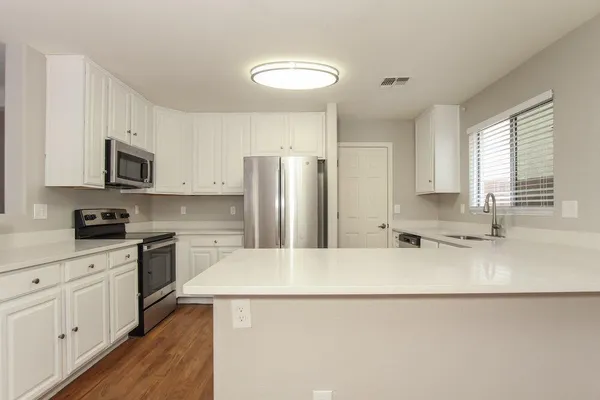 a kitchen with stainless steel appliances a refrigerator sink stove microwave and cabinets