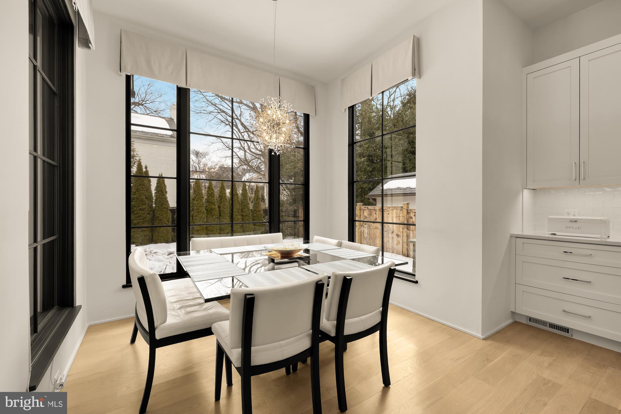 7613 Glenbrook Road Bethesda, MD 20814 - Photo 26 of 90 a view of a dining room with furniture large windows and wooden floor