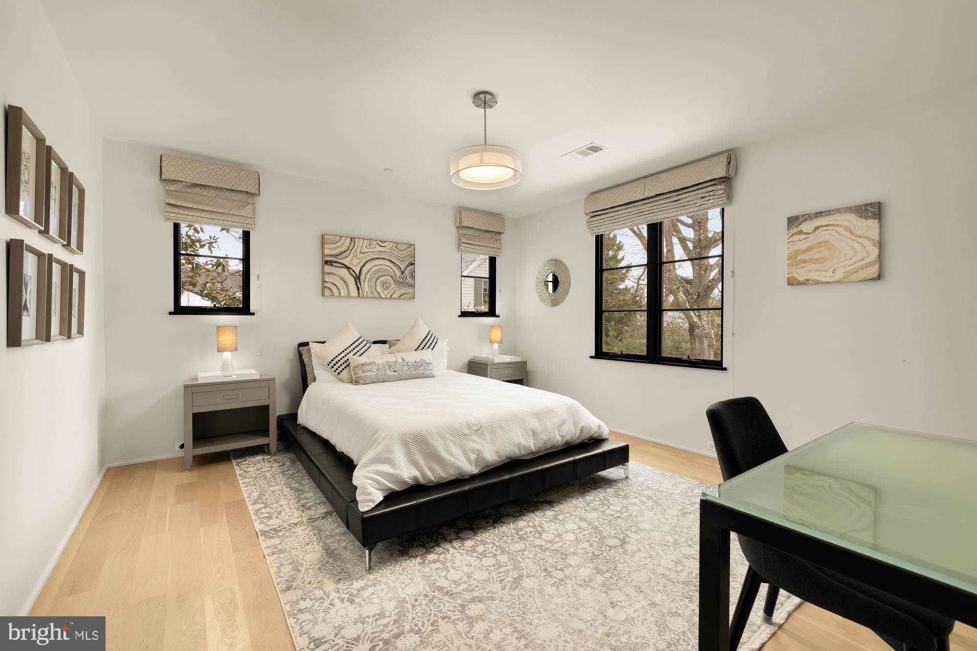 7613 Glenbrook Road Bethesda, MD 20814 - Photo 41 of 90 a spacious bedroom with a bed and a table in it