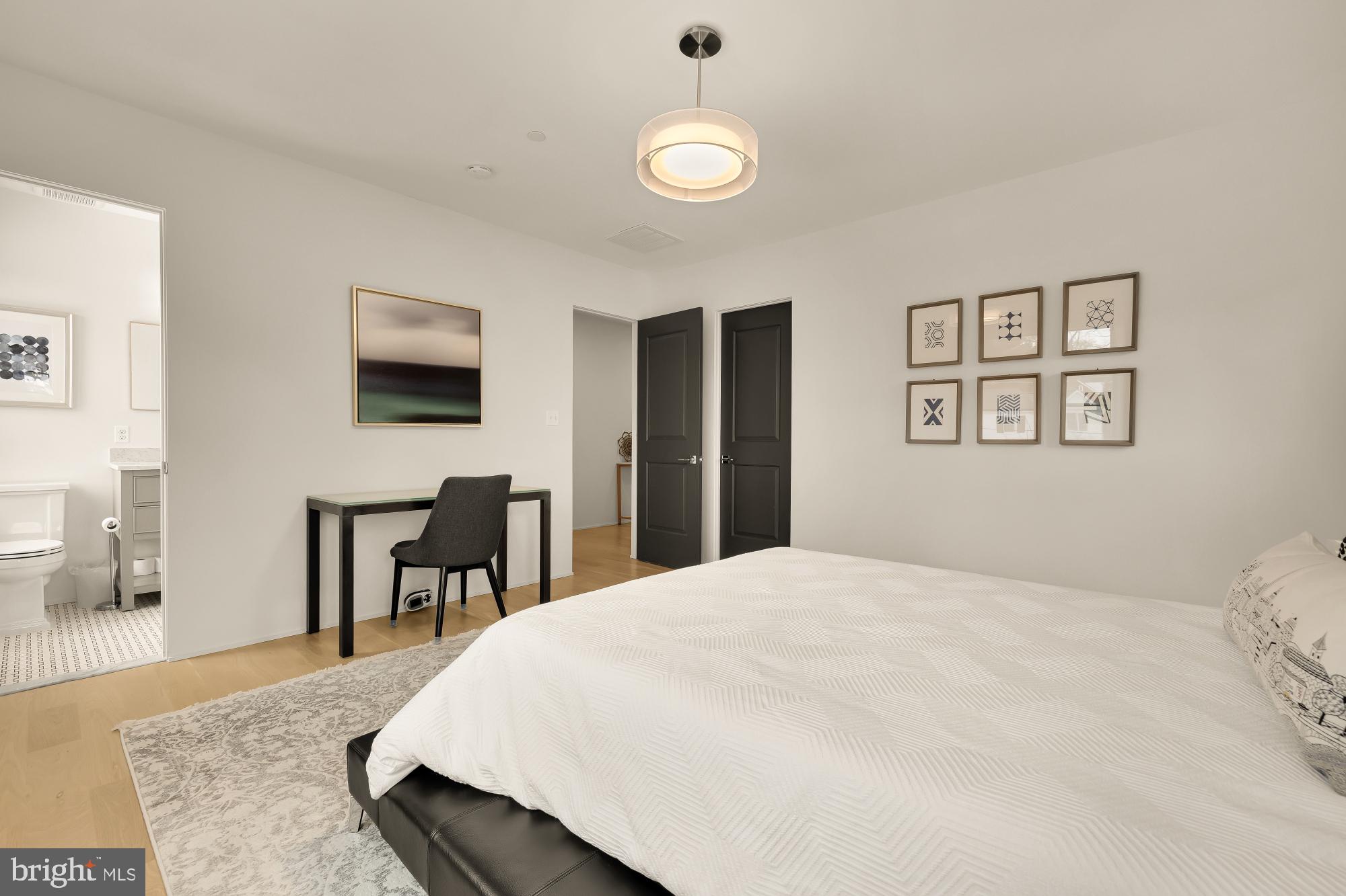7613 Glenbrook Road Bethesda, MD 20814 - Photo 62 of 90 a spacious bedroom with a bed and a table in it
