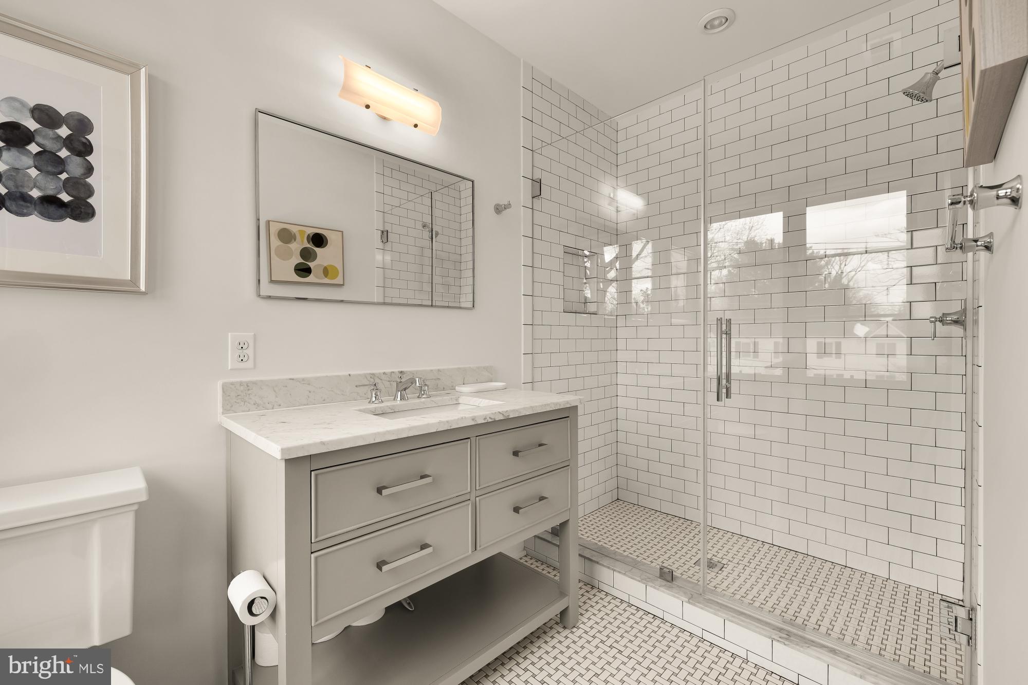 7613 Glenbrook Road Bethesda, MD 20814 - Photo 64 of 90 a bathroom with a granite countertop sink a toilet and a shower