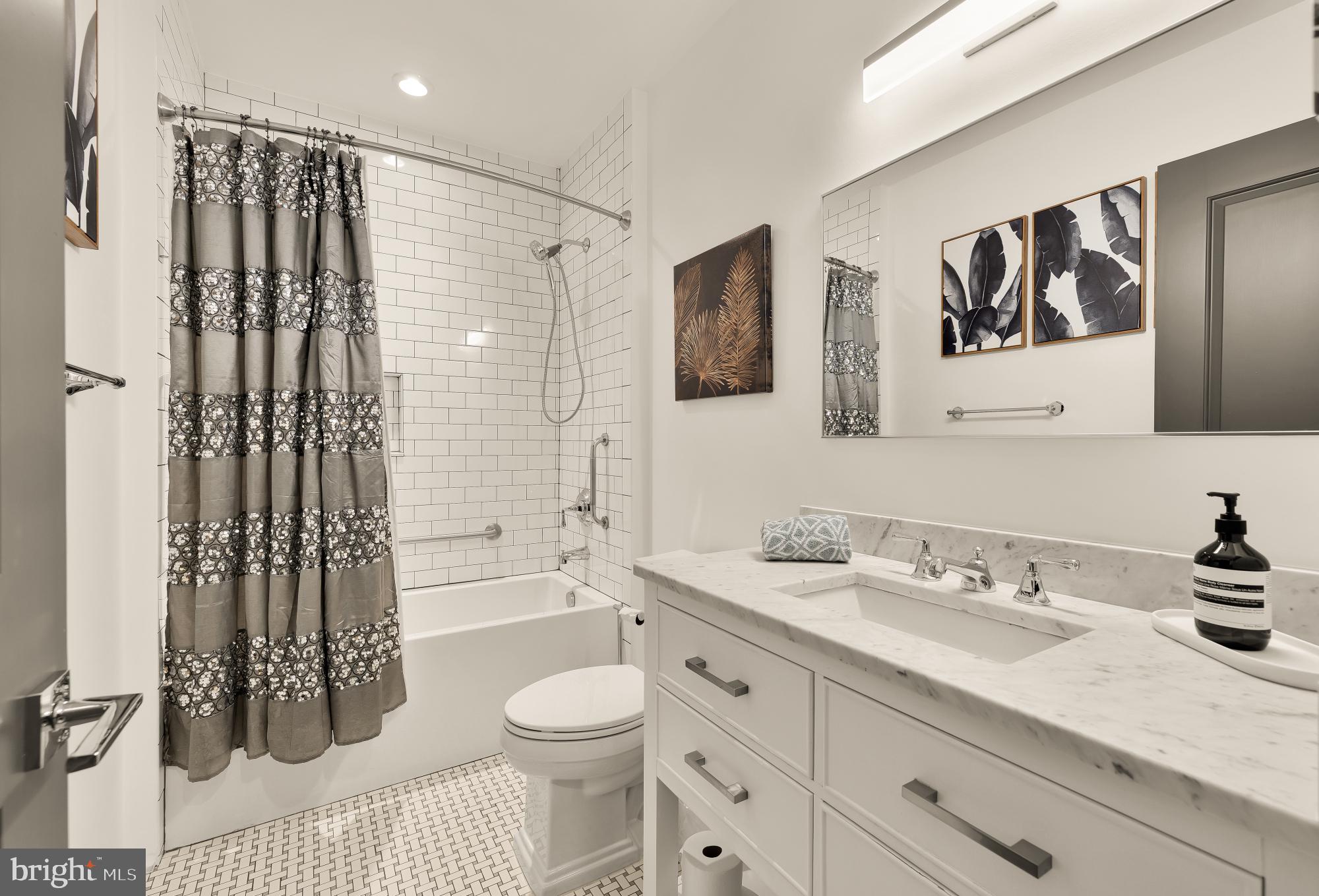 7613 Glenbrook Road Bethesda, MD 20814 - Photo 73 of 90 a bathroom with a granite countertop sink a toilet a mirror a bathtub and shower