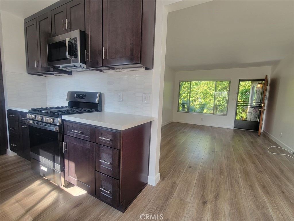 241 Newport Avenue, Unit 5 Long Beach, CA 90803 - Photo 2 of 8 a kitchen with stainless steel appliances granite countertop a stove a sink and a microwave