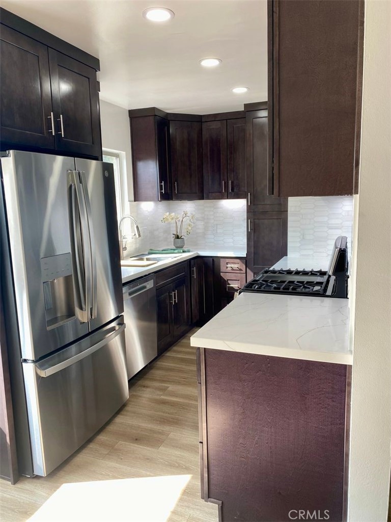 241 Newport Avenue, Unit 5 Long Beach, CA 90803 - Photo 3 of 8 a kitchen with stainless steel appliances granite countertop a refrigerator a sink and a stove