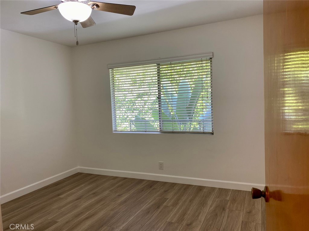 241 Newport Avenue, Unit 5 Long Beach, CA 90803 - Photo 5 of 8 a view of an empty room with wooden floor and a window