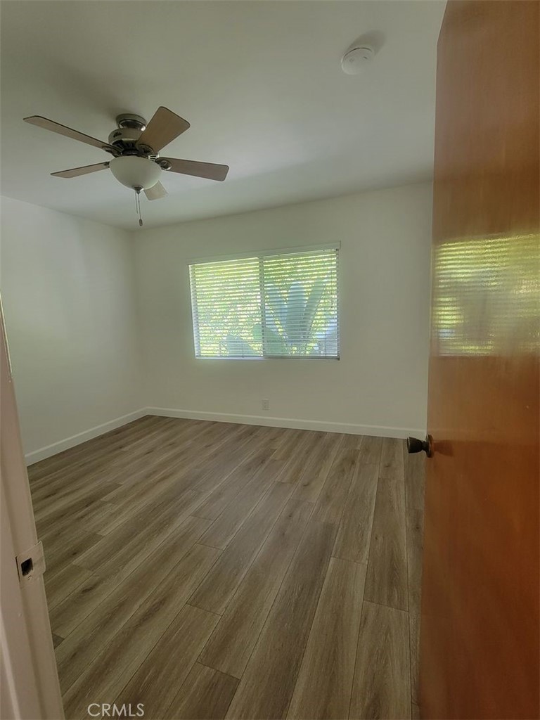 241 Newport Avenue, Unit 5 Long Beach, CA 90803 - Photo 6 of 8 a view of an empty room with wooden floor and a window