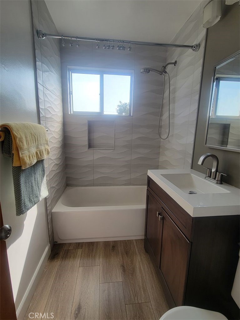 241 Newport Avenue, Unit 5 Long Beach, CA 90803 - Photo 7 of 8 a bathroom with a sink a bathtub a mirror a vanity and a shower
