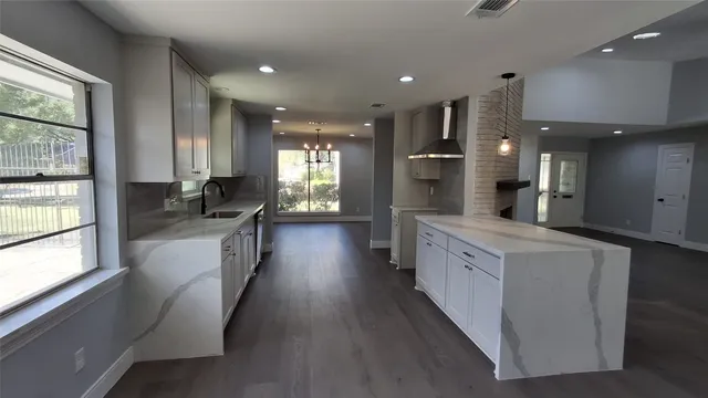 a large kitchen with kitchen island lots of counter space a sink appliances and a large window