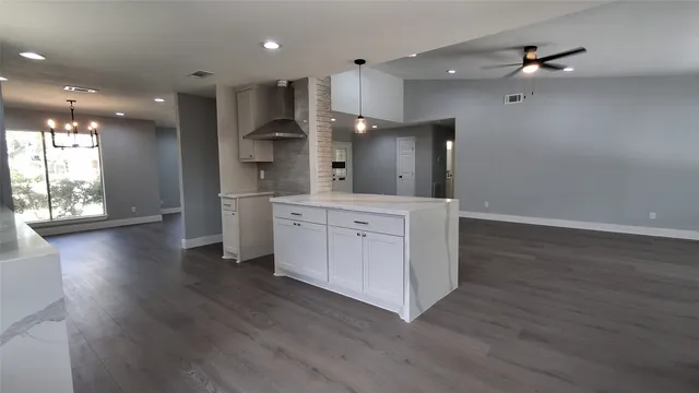 an open kitchen with a refrigerator and a sink