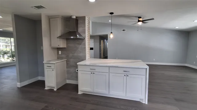 wooden floor in an empty room with a kitchen